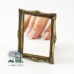 Miniaturowe lustro w złotej ramie